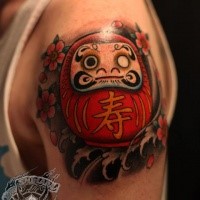 3D style colored shoulder tattoo of small daruma doll with flowers