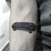 3D style cute looking wooden skateboard tattoo on forearm