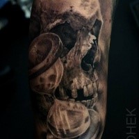 Tatouage biceps détaillé de style 3D de crâne humain avec horloge de sable par Eliot Kohek