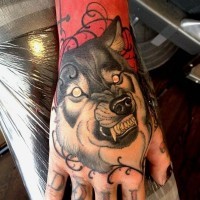 Tatuaje en la mano,  lobo demoniaco con dientes afilados