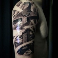 Tatuaje en el brazo,
cruz volumétrica realista con corona de espinas