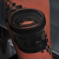 3D style realistic looking camera lens tattoo on forearm