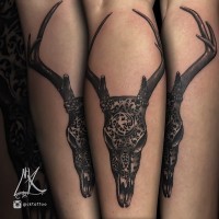 Tatuaje en la pierna, cráneo animal grande con cuernos estilizado con ornamento tribal