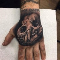 3D style very detailed hand tattoo of animal skull with lettering