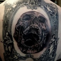 Tatuaje en la espalda,  cráneo humano horroroso en el marco antiguo
