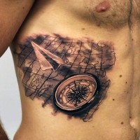 Tatuaje en las costillas, mapa del mundo con compás y avion de papel