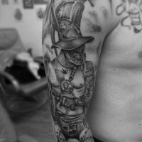 Tatuaje en el hombro, gladiador intrépido con montón de cráneos