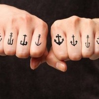A lot of different tiny black anchors tattoo on each finger