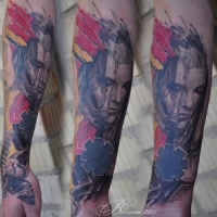 Abstract tattoo with human face and moth on forearm