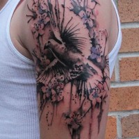 Tattoo von erstaunlicher schwarzweißer Taube mit Blumen in Spritzen am Oberarm