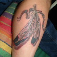 Tatuaje en la pierna, plumas abigarradas con collar