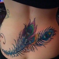 Tatuaje en la espalda baja, 
plumas de pavo real de varios colores