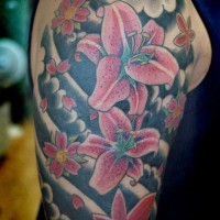 Awesome pink fapanese lily flowers in black clouds tattoo on upper arm