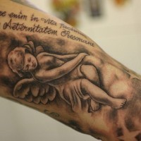 Tatuaje en el brazo,
ángel hermoso con inscripción latina