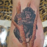 Fuß Tattoo mit schönem schwarzem hängendem auf Baumzweigen Schimpanse