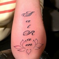 Tattoo mit schön geschriebenem Namen  und Lotos am Arm