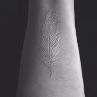 Beautiful white-ink feather tattoo on wrist
