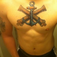 Tatuaje en el pecho, 
ancla azul con cañones cruzados