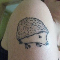 Black-and-white hedgehog tattoo on shoulder
