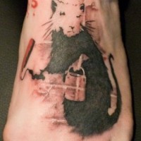 Tatuaje en el pie, rata de color negro y blanco con el cubo