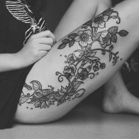 Black-and-white wildflowers tattoo on thigh