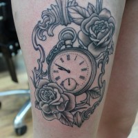 Black-ink flowers in mirror frame with watch tattoo on thigh