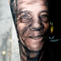 Lo stile nero e grigio ha dettagliato il tatuaggio dell'avambraccio del volto di un vecchio uomo
