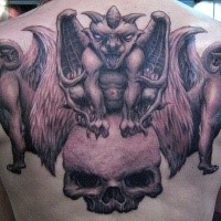 Black and gray style large human skull tattoo combined with gargoyles