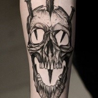 Black ink skull with nails forearm tattoo by Bartosz Wojda