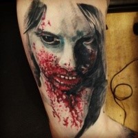 Bloody colored upper arm tattoo of zombie woman face