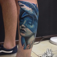 Tatuagem de cores azuis com mulher e tubarão