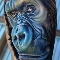Cartoon blue-muzzle gorilla tattoo on arm