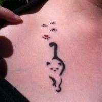 Tatuaggio delicato sulla clavicola il disegno del gattino e le tracce