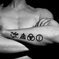 Tattoo von klassischen schwarzen Zeichen in Tusche am Unterarm