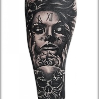 Reloj hecho frente a la muchacha del tatuaje en el antebrazo