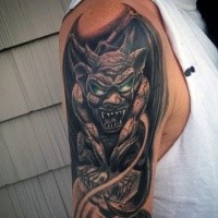 Colored creative designed upper arm tattoo of gargoyle with green eyes