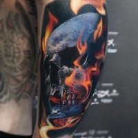 Colored skull with flames tattoo on shoulder by Valentina Ryabova