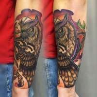 Tatuagem de coruja colorida no antebraço
