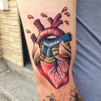 Tatuaje en el brazo, corazón humano con gotas de sangre