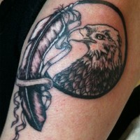 Cool black-and-white eagle portrait and ribboned feather tattoo on arm