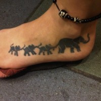 Cool black-colored elephant family tattoo on foot