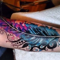 Cool blue-and-pink tribal feather tattoo on arm