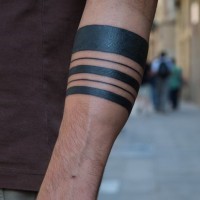 Cool different-line black-ink tribal band tattoo on forearm