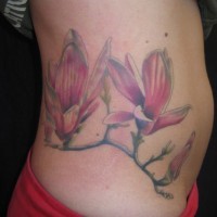 Cool pink magnolia flowers on branch tattoo on hip