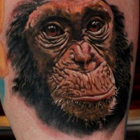 Cute colorful chimpanzee face tattoo on thigh