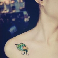 carina piccola piuma colorata tatuaggio su spalla di ragazza