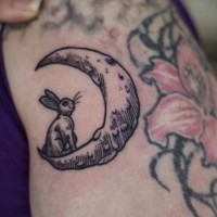 Tattoo mit süßem mädchenhaftem Hase auf dem Mond in Schwarz auf der Seite