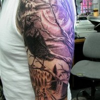 Dark gloomy raven in graveyard tattoo on upper arm