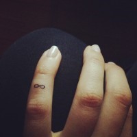 Elegant small infinity symbol tattoo on finger