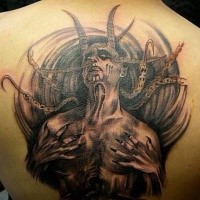 Enormous black ink upper back tattoo of devil monster with chains